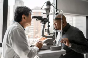 Doctor examining a patient's eyes during an ophthalmology clinic appointment.